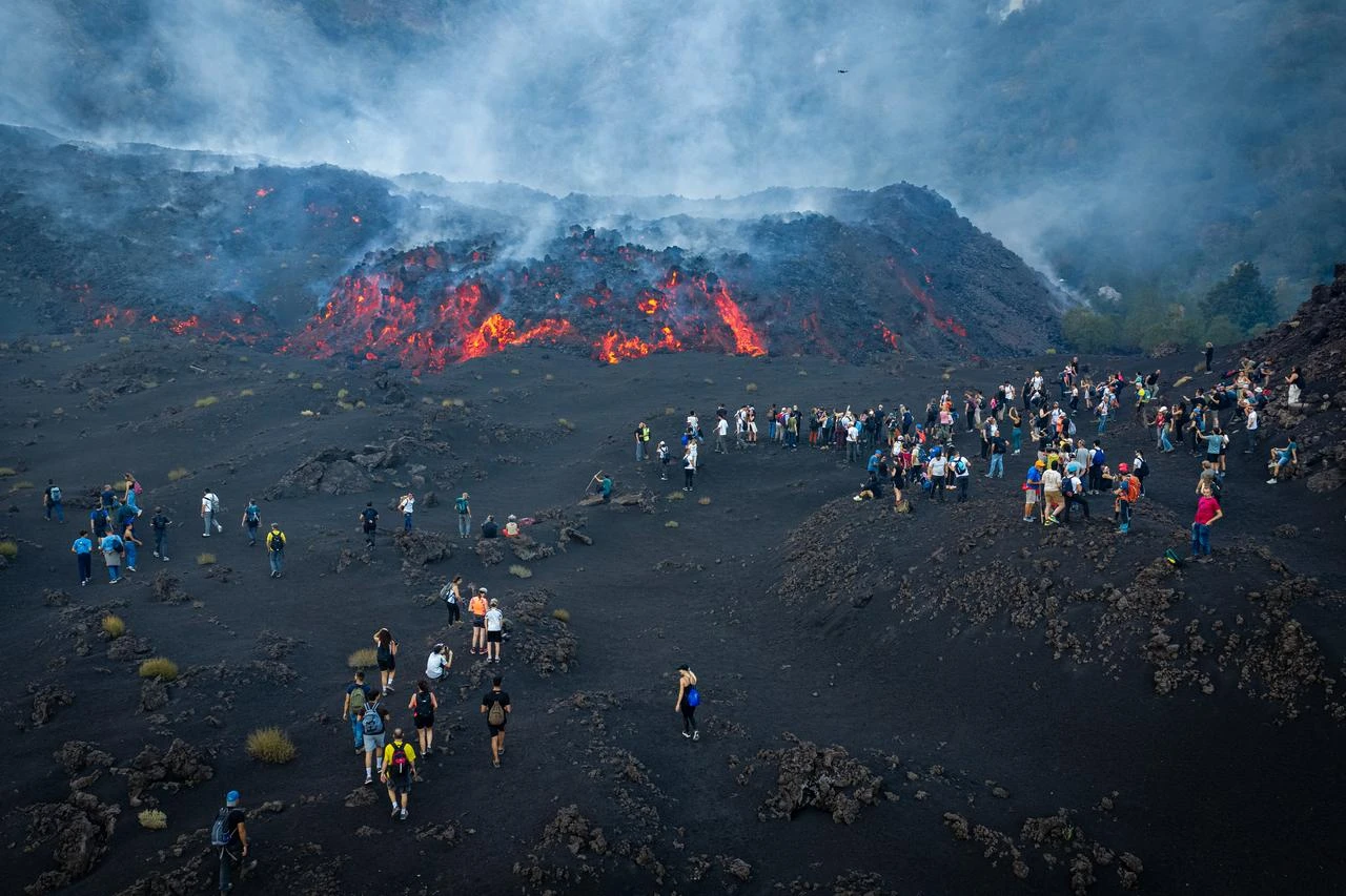 Visitors watch lava flows during an eruption of Mount Etna in Sicily, Italy, Aug. 12, 2026. (AFP Photo)