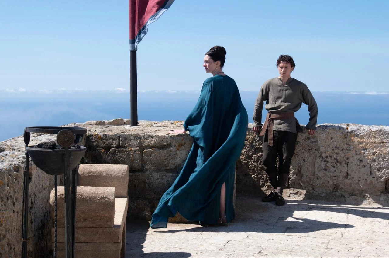 Anne Hathaway (L) as Penelope and Tom Holland as Telemachus, in a scene from "The Odyssey." (Photo via Universal Pictures)