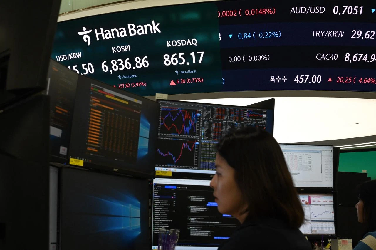 A dealer works near a screen showing South Korea’s benchmark KOSPI stocks index in a foreign exchange dealing room at the Hana Bank headquarters in Seoul on August 13, 2026. (AFP Photo)