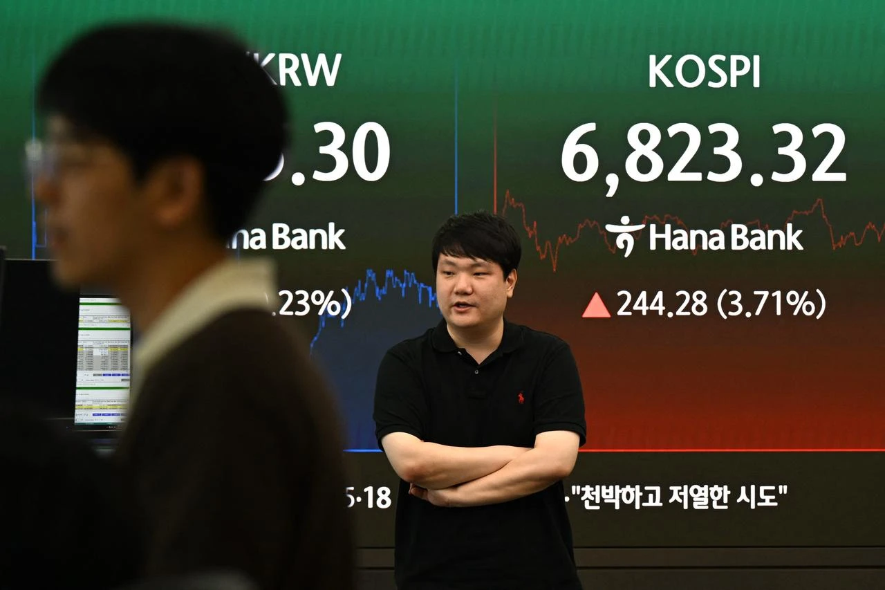 Dealers work near a screen showing South Korea’s benchmark KOSPI stocks index in a foreign exchange dealing room at the Hana Bank headquarters in Seoul on August 13, 2026. (AFP Photo)