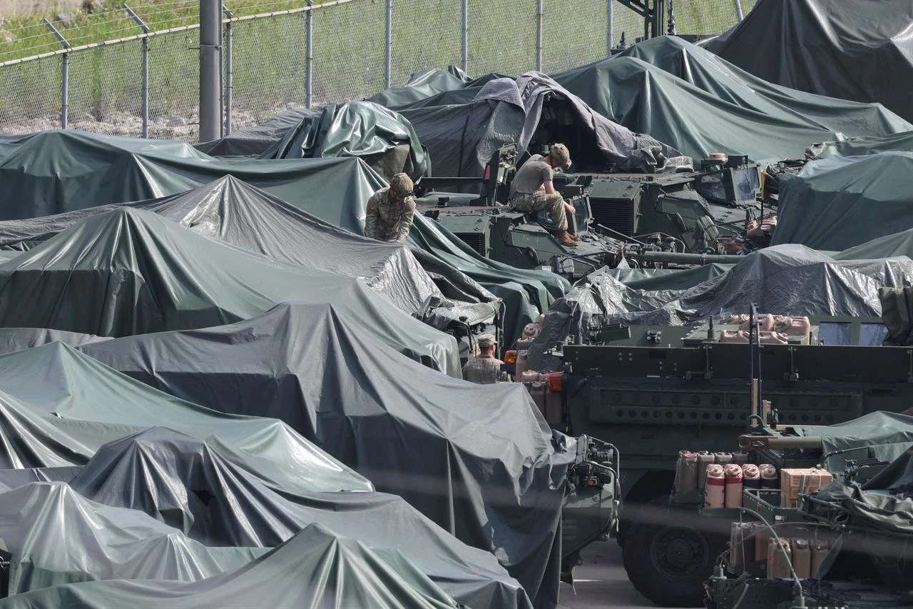 Military vehicles covered with tarps are parked at a US Army base in Dongducheon, South Korea, August 18, 2026. (Photo by YONHAP / AFP)