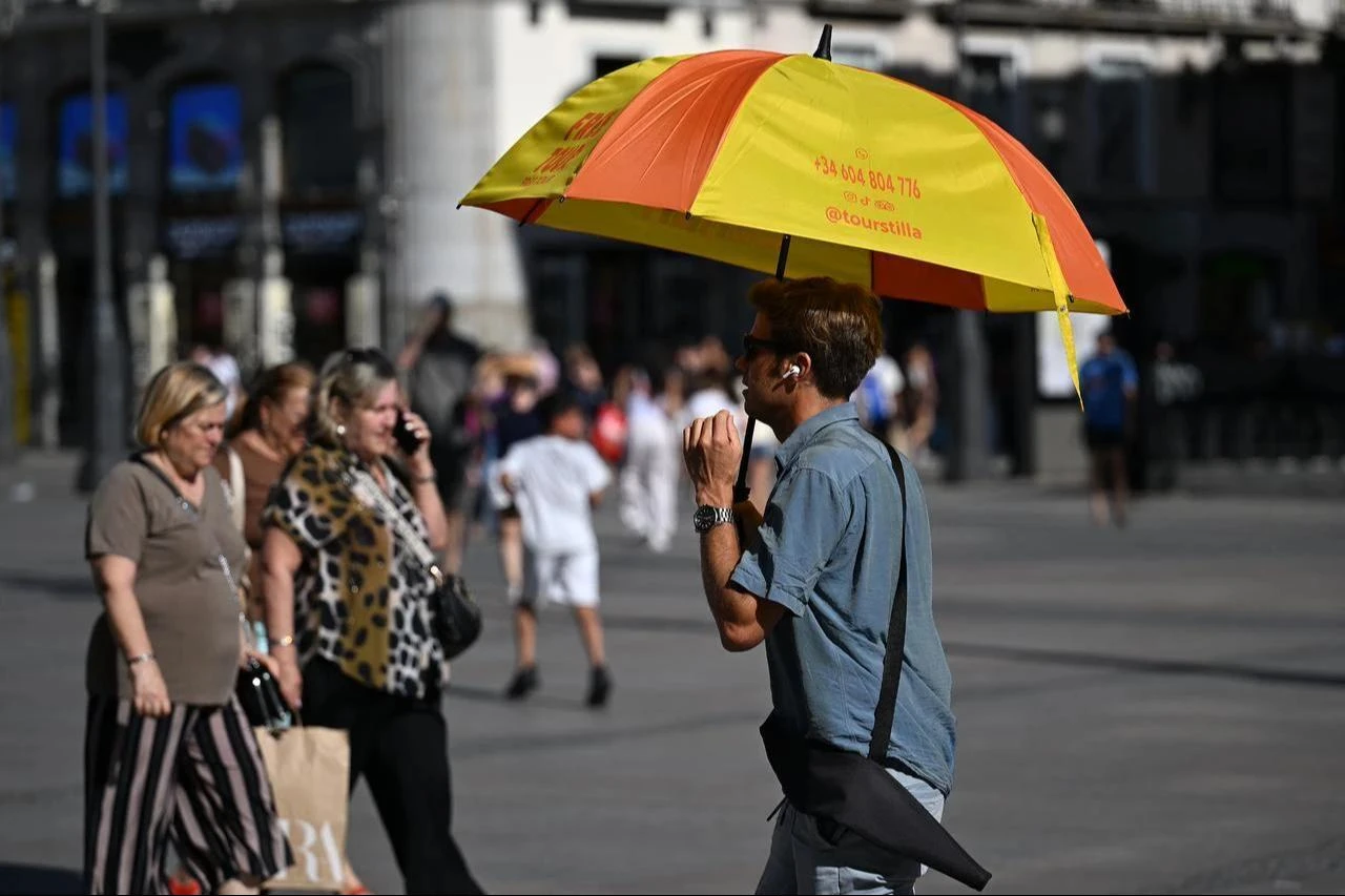 People protect themselves from the heatwave that affects daily life as high temperatures continue in Madrid, Spain, June 26, 2026. (AA Photo)