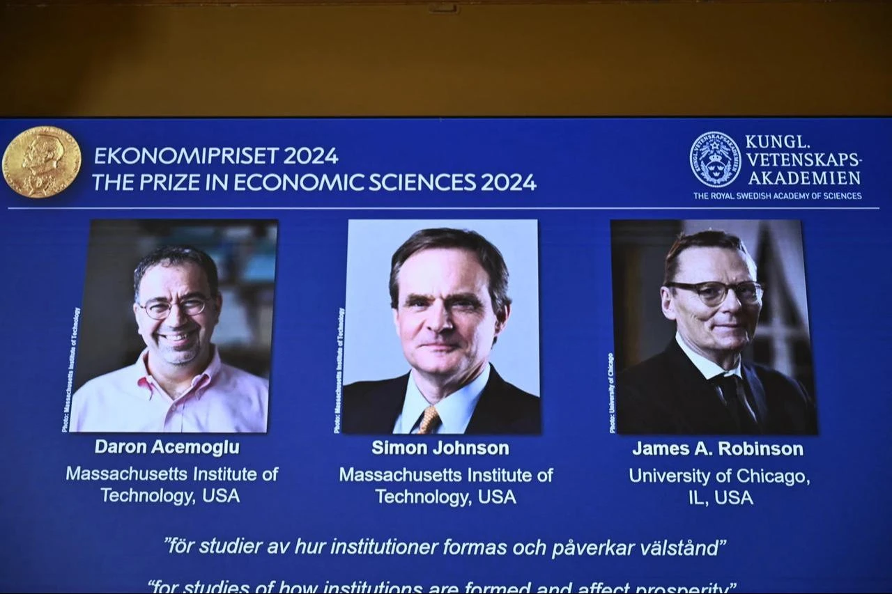 Screen shows the laureates (L-R) Turkish-American Daron Acemoglu and British-Americans Simon Johnson and James Robinson of the 2024 Sveriges Riksbank Prize in Economic Sciences in Memory of Alfred Nobel during the announcement by the Royal Swedish Academy of Sciences in Stockholm, Sweden on October 14, 2024. (AFP Photo)