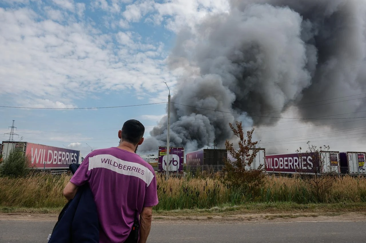 A Wildberries emloyee looks at a plume of smoke rising during a fire at Russian e-commerce firm Wildberries' logistics complex near the town of Podolsk, outside Moscow on August 16, 2026. (AFP Photo)
