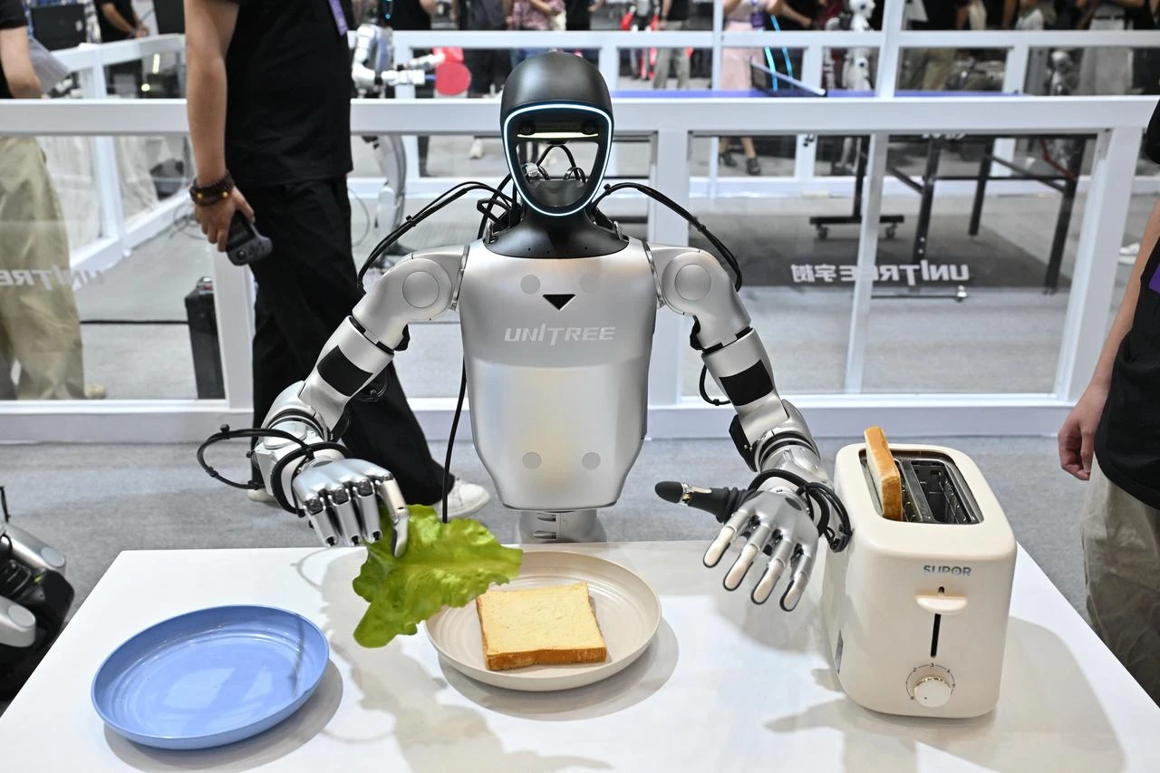 A Unitree humanoid robot prepares a sandwich during the 2026 World Robot Conference in Beijing on August 19, 2026. (AFP Photo)
