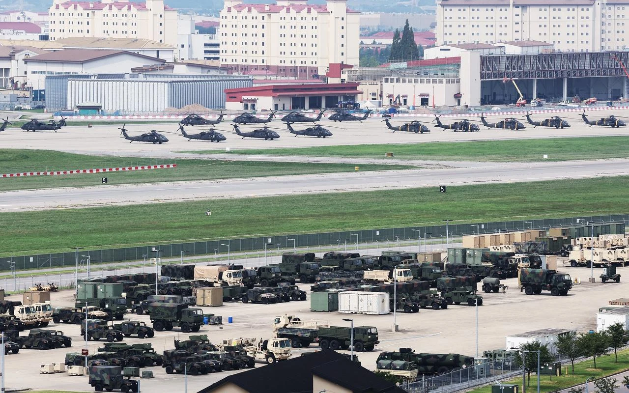 US military vehicles and US Army UH-60 Black Hawk helicopters (top) are seen at Camp Humphreys in Pyeongtaek on August 19, 2026. (Photo by YONHAP / AFP)