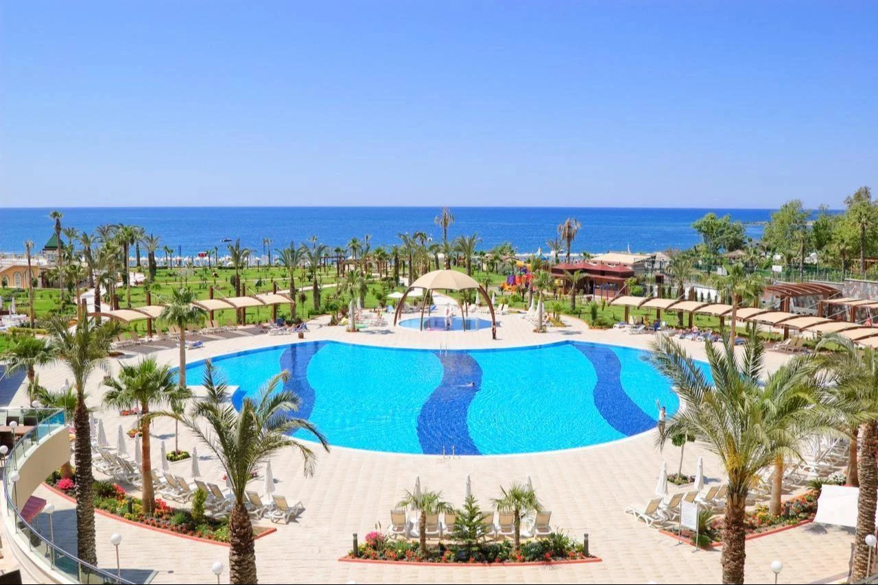 Vacationers relax around a resort pool overlooking the Mediterranean coast at a luxury hotel in Antalya, Türkiye. (Adobe Stock Photo)