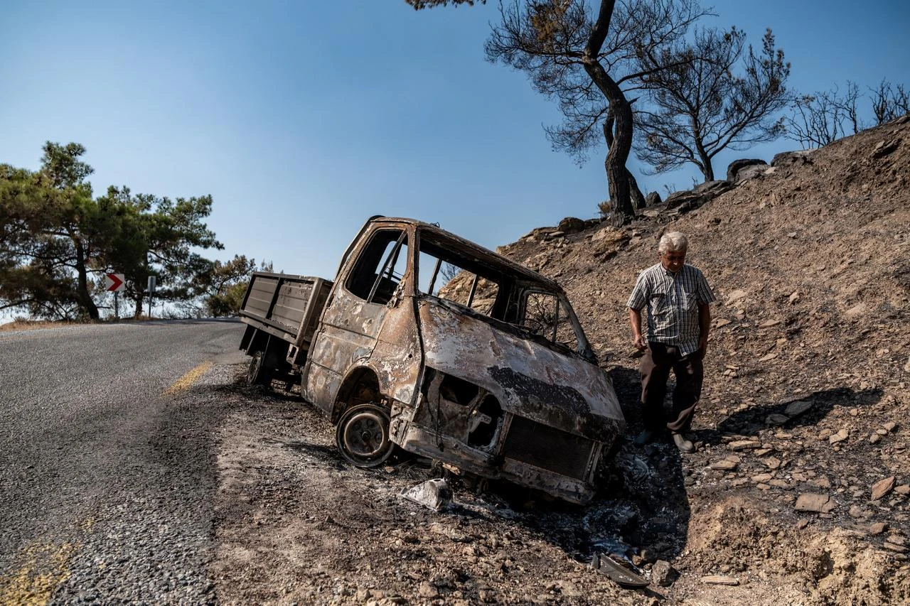 Farmer Hakan Akbas checks his burnt vehicle next to burnt plants and trees in the forest following a wildfire at Cine district, in Aydin, Türkiye, on August 1, 2026. (AFP Photo)