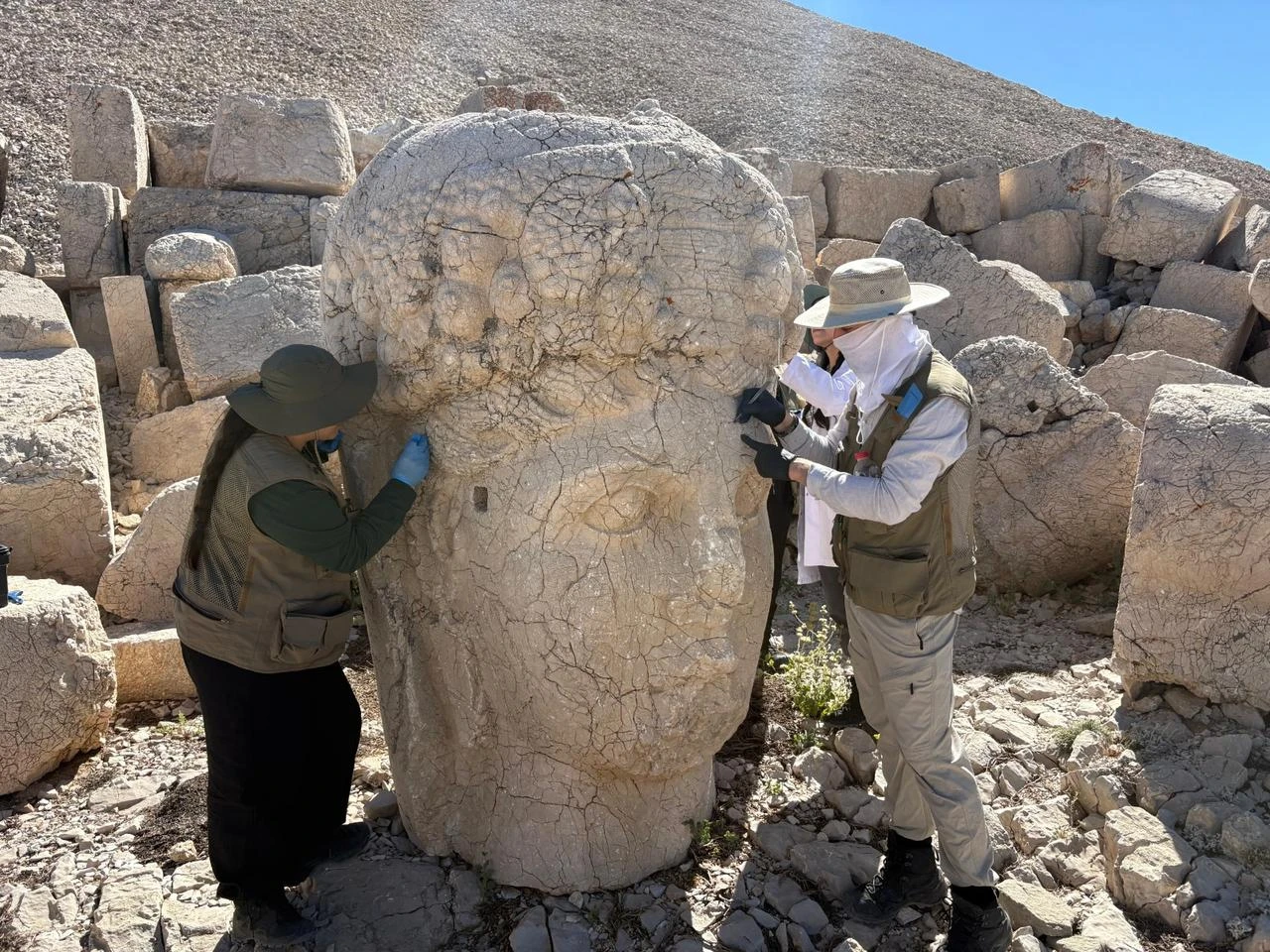 Conservation specialists work on one of Mount Nemrut's monumental stone heads as part of the site's ongoing preservation program in Türkiye. (Photo via Ministry of Culture and Tourism)