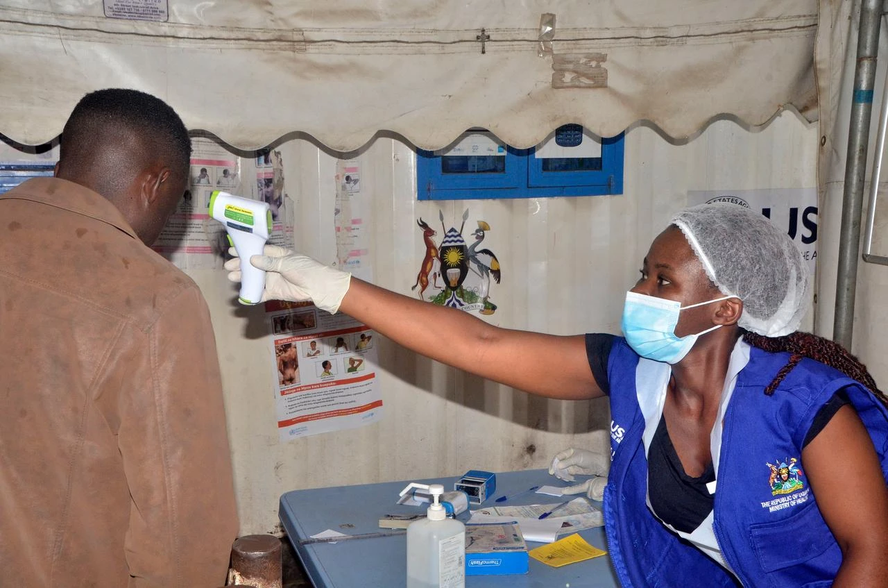 A health worker checks a traveler’s temperature as Uganda steps up Ebola screening at the Mpondwe Border Crossing with the Democratic Republic of the Congo, May 23, 2026. (AA Photo)
