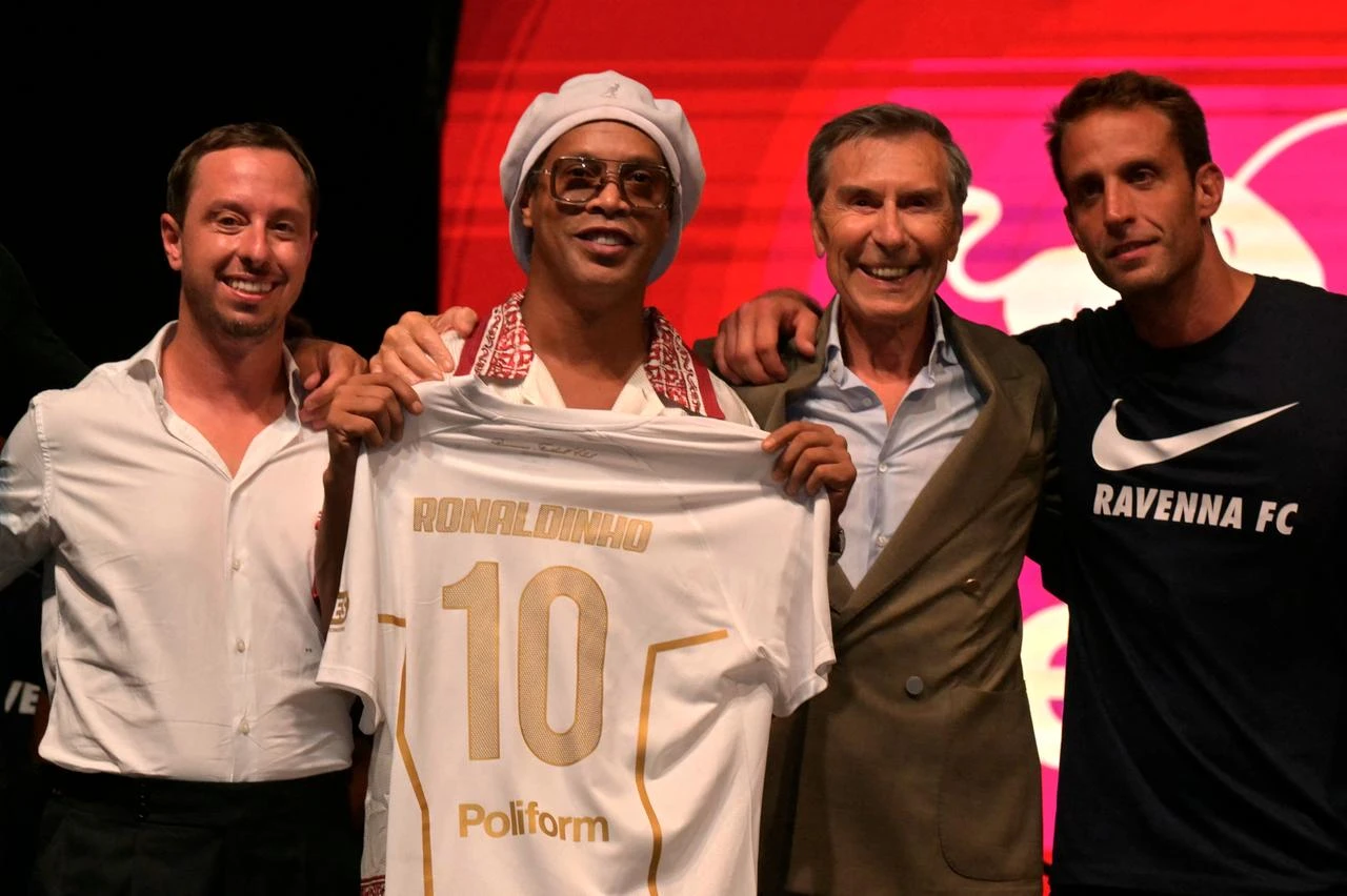 Brazilian football legend Ronaldinho holds a Ravenna FC No. 10 jersey alongside club representatives during the team’s presentation in Marina di Ravenna, Italy, Aug. 20, 2026. (AFP Photo)