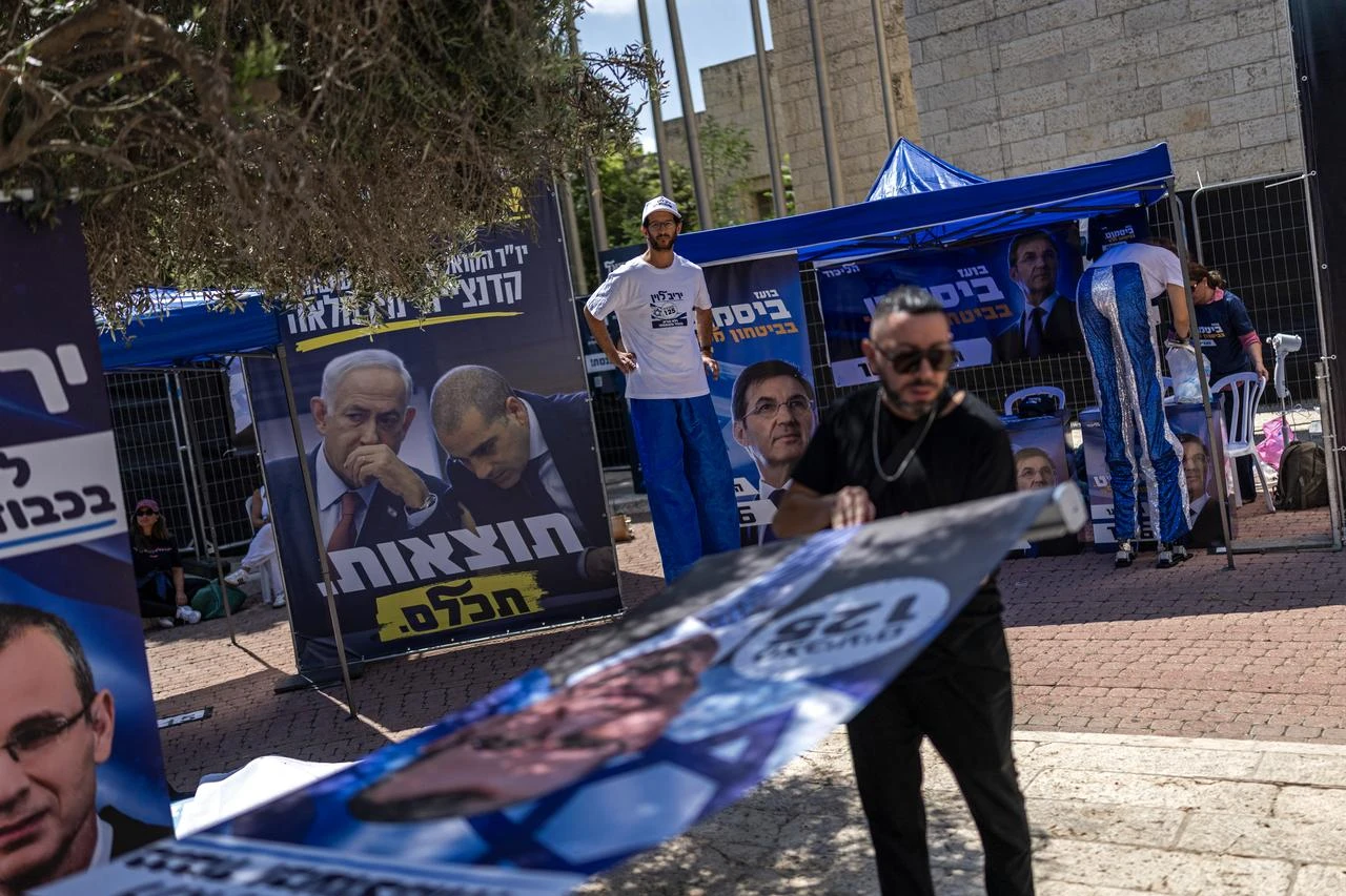 Supporters of Likud party stand amid stalls and posters installed outside a polling station during primary elections of their party ahead of country's national elections, in Jerusalem on August 17, 2026. (AFP Photo)