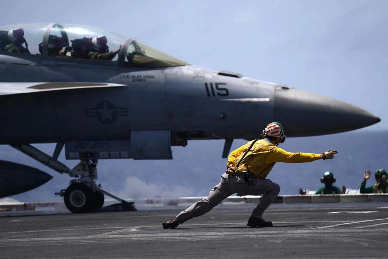 A US Navy aviation boatswain’s mate directs a F/A-18F Super Hornet assigned to Strike Force Squadron (VFA) 154 on the flight deck aboard the aircraft carrier USS Theodore Roosevelt (CVN-71) while the ship is moored in Honolulu, Hawaii, during Exercise RIMPAC (Rim of the Pacific) 2026 on July 17, 2026. (AFP Photo)