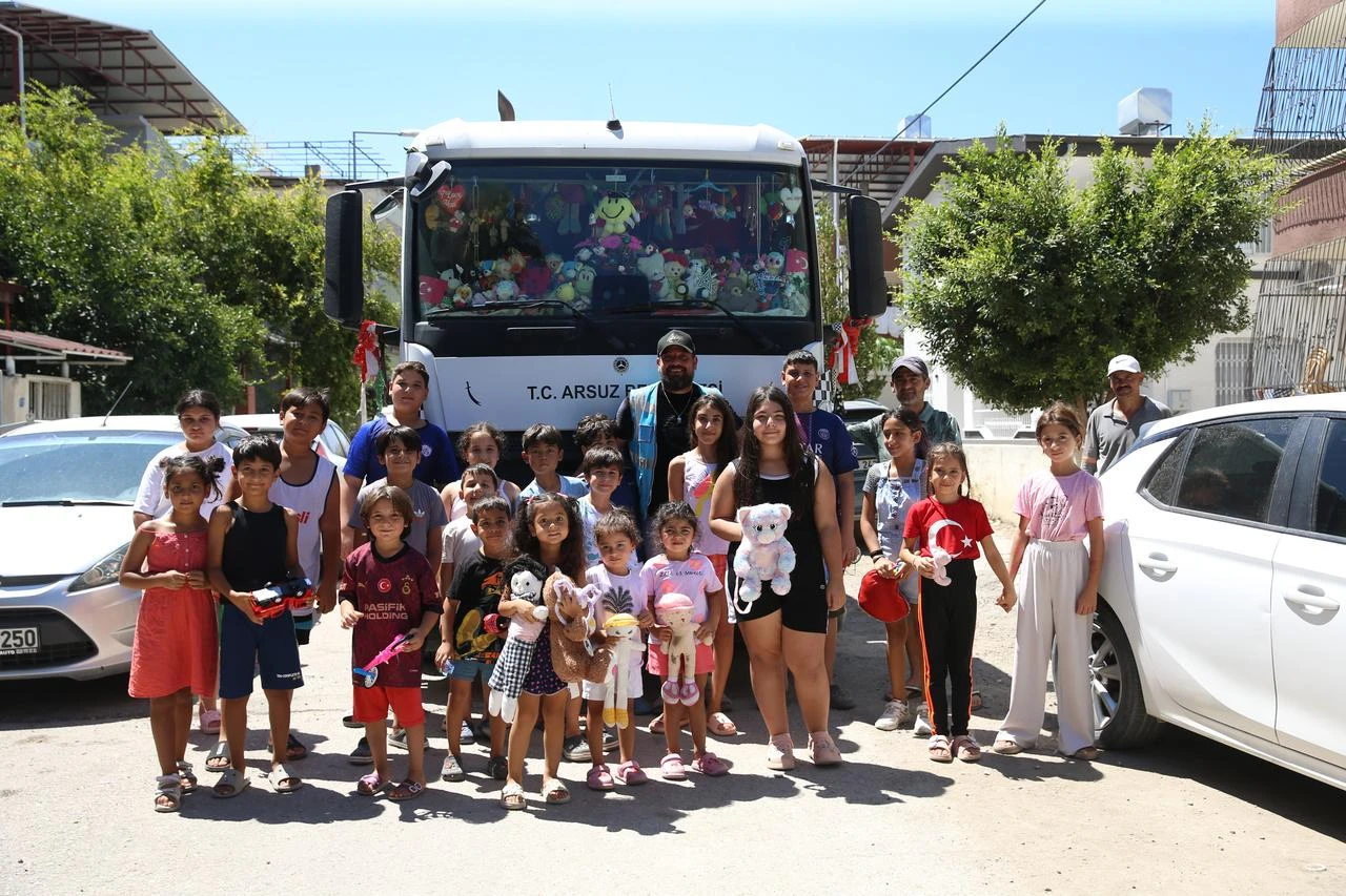 Children pose with an Arsuz Municipality sanitation worker in front of a garbage truck decorated with toys in Arsuz, Hatay, Türkiye, Aug. 23, 2026. (AA Photo)