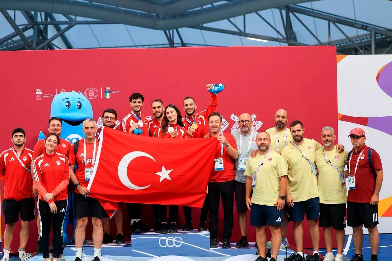 Members of Türkiye’s fencing delegation pose with the national flag after winning medals in the individual sabre events at the 20th Mediterranean Games in Taranto, Italy, Aug. 22, 2026. (AA Photo)