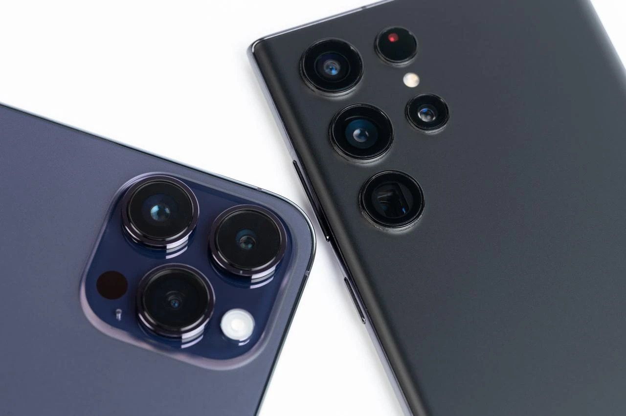 Apple iPhone and Samsung smartphone camera systems are shown in a close-up product image. (Adobe Stock Photo)