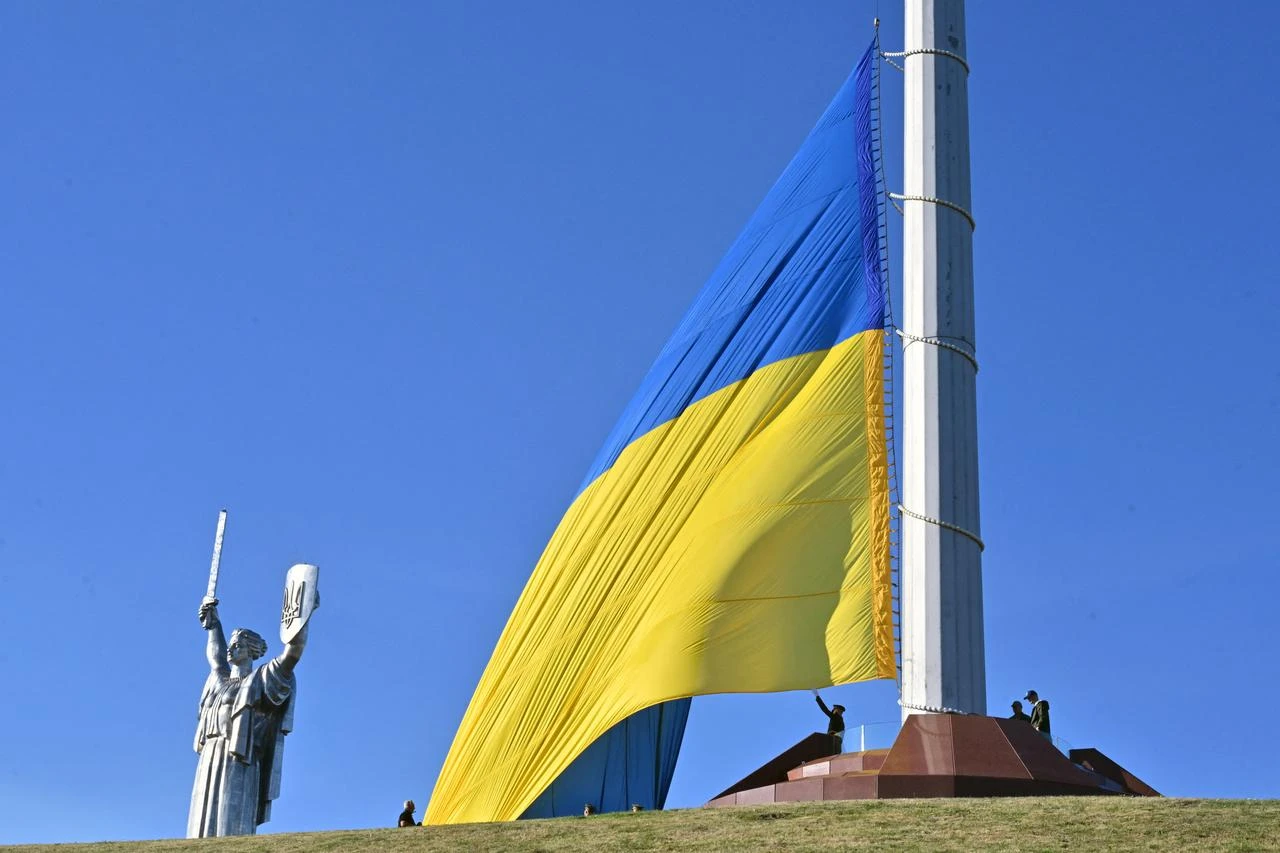 Ukrainian servicemen raise up the biggest national flag in the country on a flagpole in front of Motherland Monument during a ceremony marking the National Flag Day of Ukraine in Kyiv on August 23, 2026, amid Russian invaion of Ukraine. (AFP Photo)