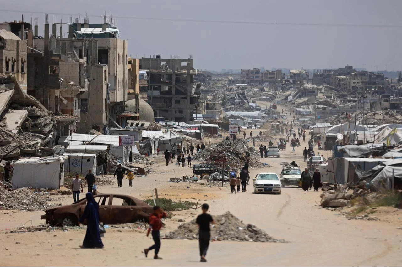 Displaced Palestinians make their way along a street with destroyed buildings at Jabalia in the northern Gaza Strip, May 6, 2026. (AFP Photo)
