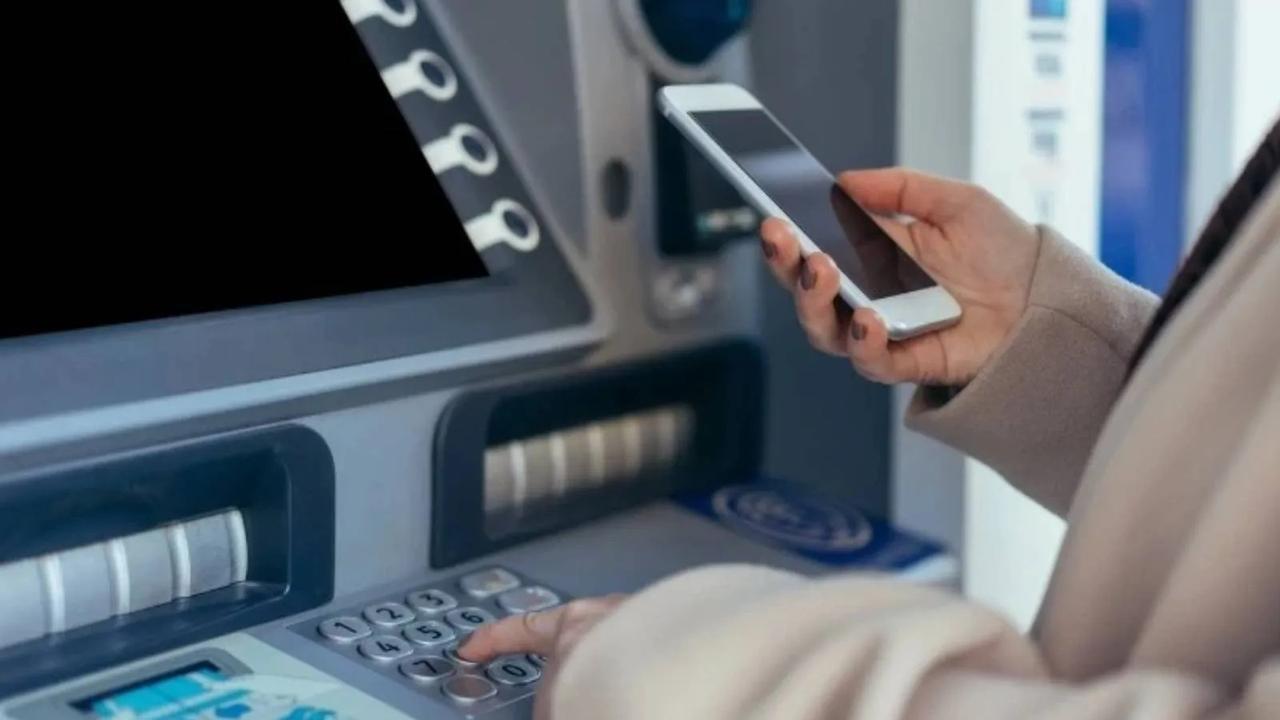 A customer uses a smartphone at an ATM in Türkiye. (Adobe Stock Photo)