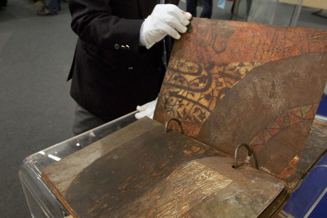 Visitor leafs through Iraqi artist Sliman Mansour's book "The Complete Tales of a Deceased Nobody", made of rusted metal sheets, at the exhibition "Contemporary Book Art of the Arab World" during the Frankfurt Book Fair 08 October 2004. (AFP Photo)