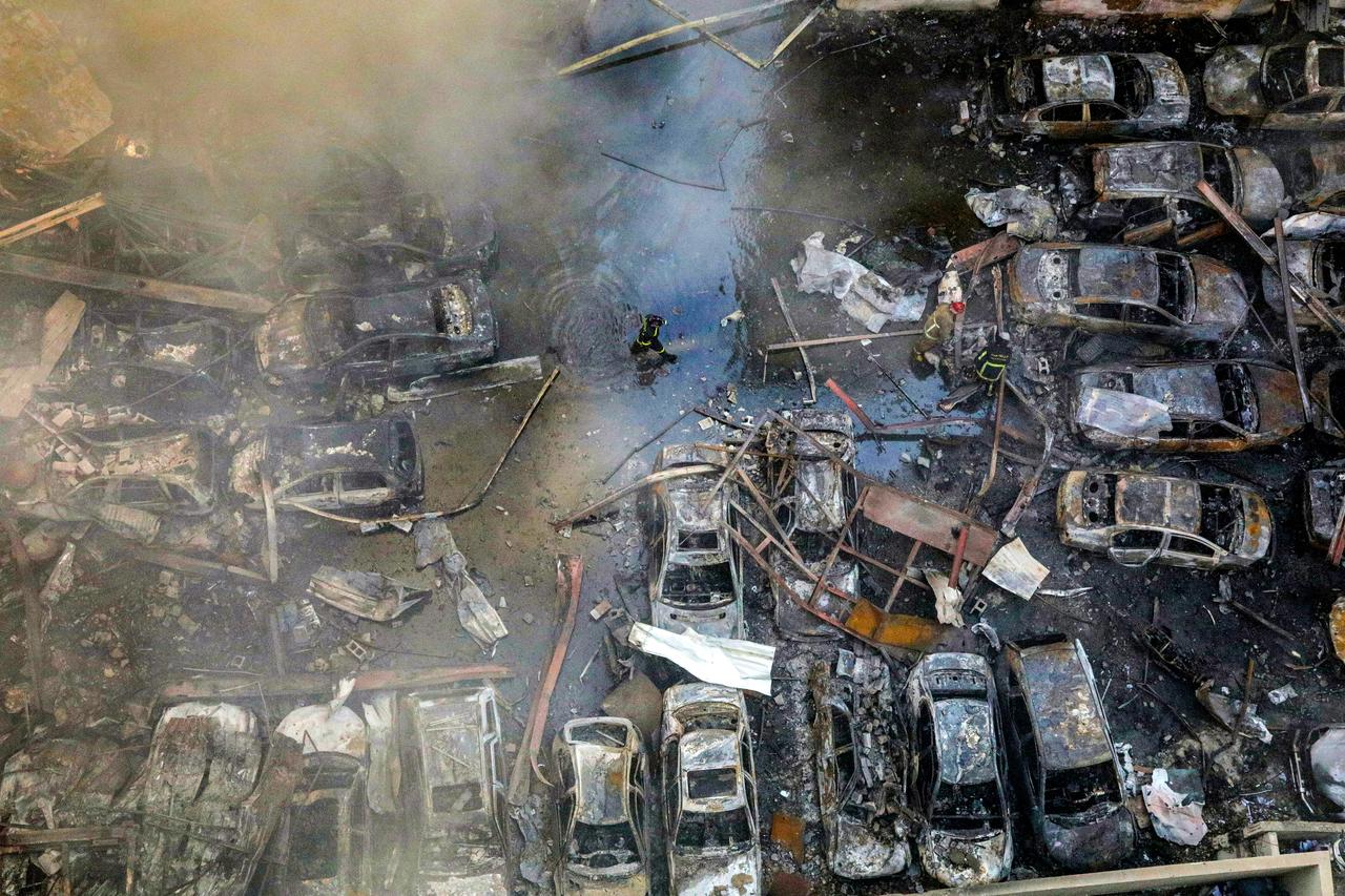 A firefighter walks past destroyed vehicles as colleagues attempt to extinguish a fire following an Israeli strike at the Corniche al-Mazraa neighbourhood of Beirut on April 8, 2026. (AFP File Photo)