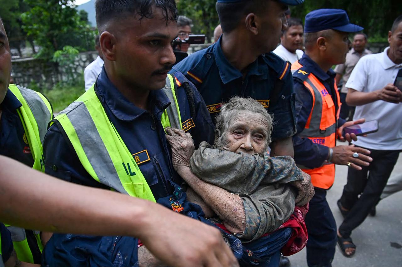 Rescue personnel carry a person affected by flash floods at Devghat in Nepal's Nuwakot district on August 26, 2026. (AFP Photo)