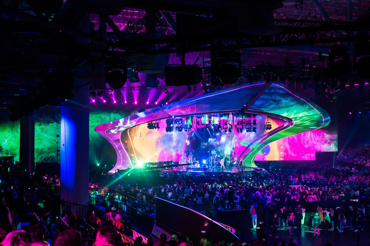 A brightly lit stage and large crowd are seen during a live music event associated with the Eurovision Song Contest. (Adobe Stock Photo)