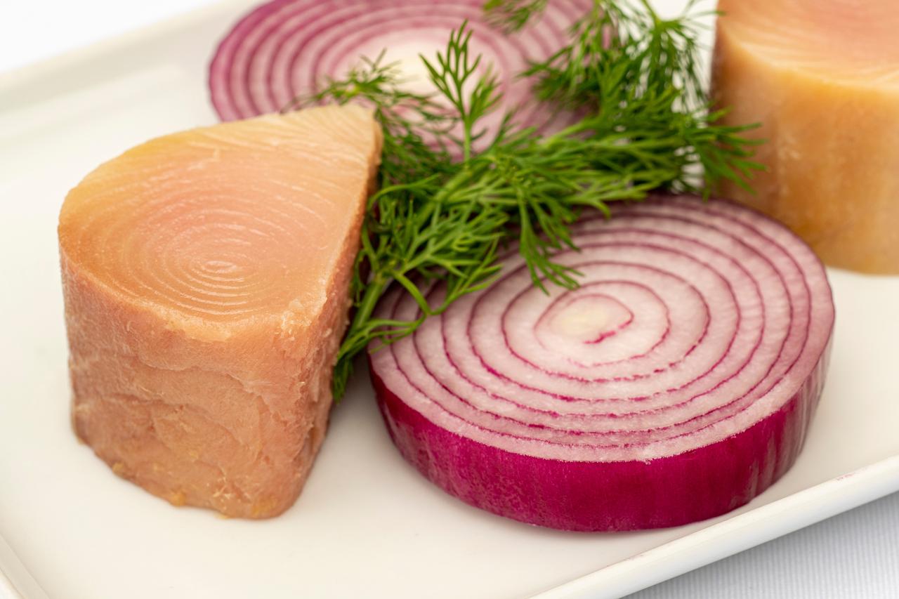 Traditional lakerda, thick-cut, served with red onion rings and dill sprigs. (Adobe Stock Photo)