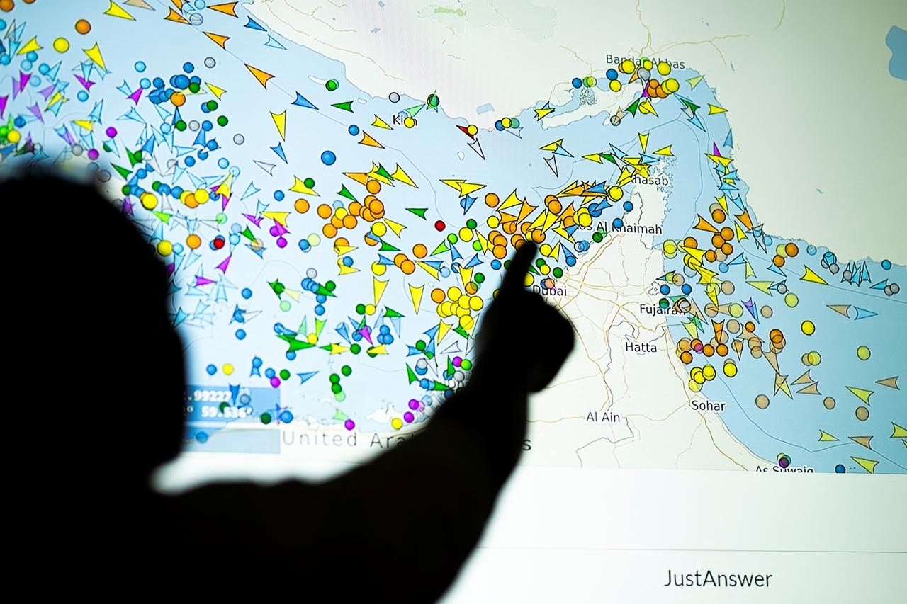 A photo illustration taken in Nicosia on May 4, 2026, shows a person in front of a large screen displaying vessel movements in the Strait of Hormuz on a ship-tracking website. (AFP File Photo)