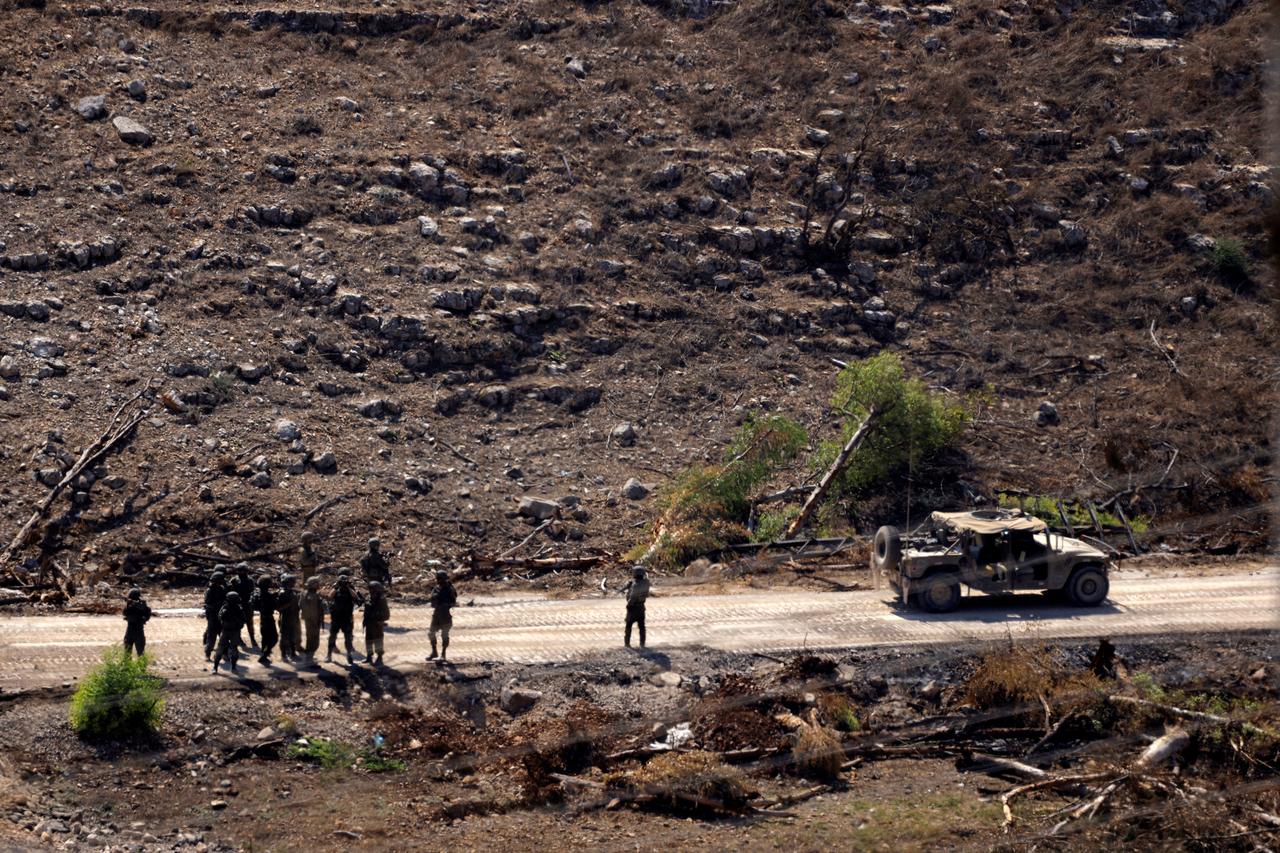 A photograph taken from the southern Lebanese village of Chaqra shows an Israeli military convoy and solider in the nearby area of Wadi al-Slouki on August 21, 2026. (AFP Photo)