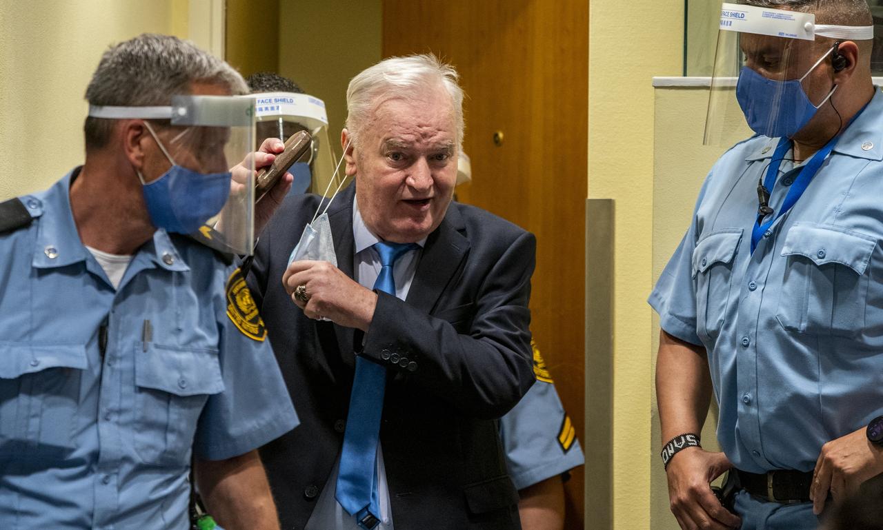 Ratko Mladic removes his facemask as he arrives in the courtroom prior to the hearing of the final verdict on appeal against his genocide conviction over the 1995 Srebrenica massacre, Europe's worst act of bloodshed since World War II, on June 8, 2021 at the International Residual Mechanism for Criminal Tribunals (IRMCT) in The Hague. (AFP File Photo)