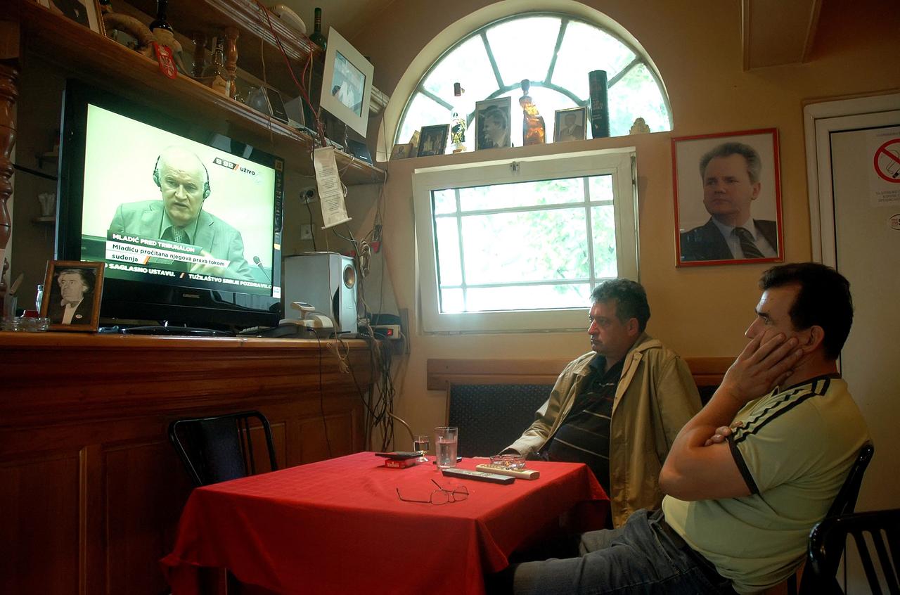 Two men watch the live broadcast of wartime Bosnian Serb army chief Ratko Mladic's appearance before the International Criminal Tribunal for the former Yugoslavia in a coffee shop in Belgrade on June 3, 2011. (AFP Photo)