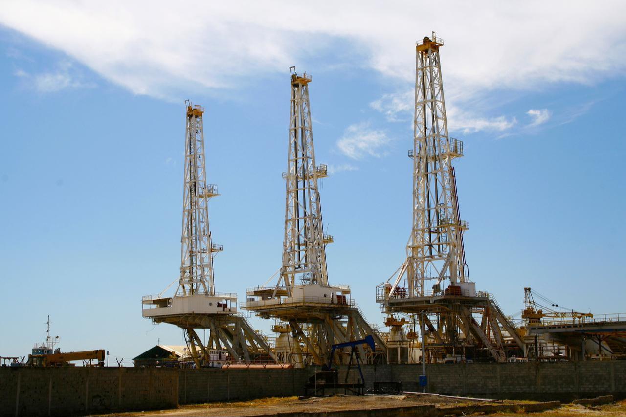 Oil towers in a PDVSA workshop yard next to a pump jack in Cabimas, Zulia, Venezuela. (Adobe Stock Photo)