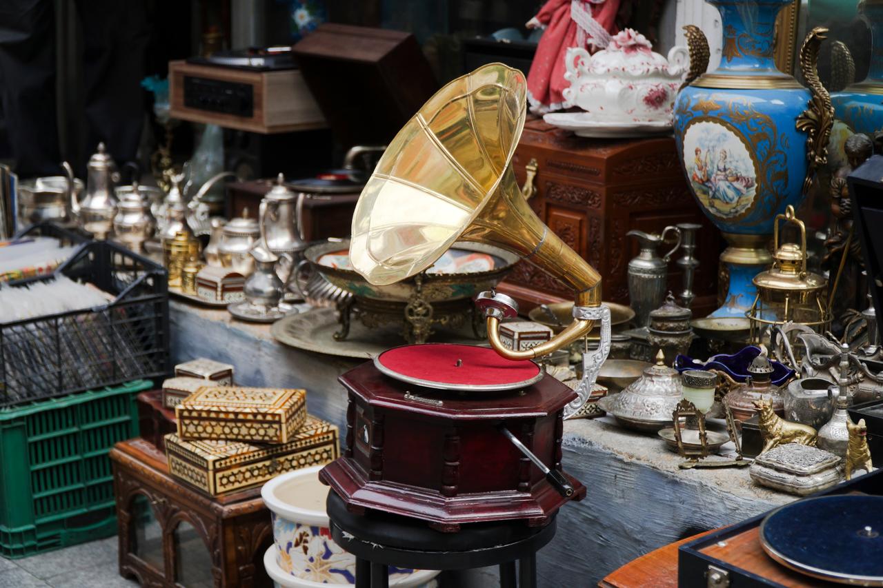 An antique gramophone is displayed among vintage objects and collectibles at a market stall in Türkiye. (Adobe Stock Photo)