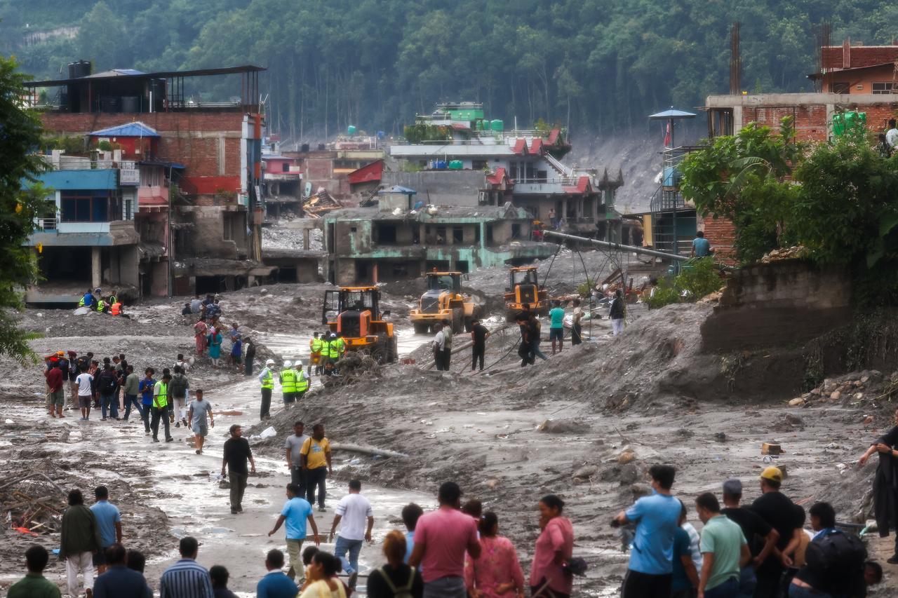 Residents and emergency workers survey widespread damage after flash floods struck a settlement in Nepal, Aug. 29, 2026. (AA Photo)