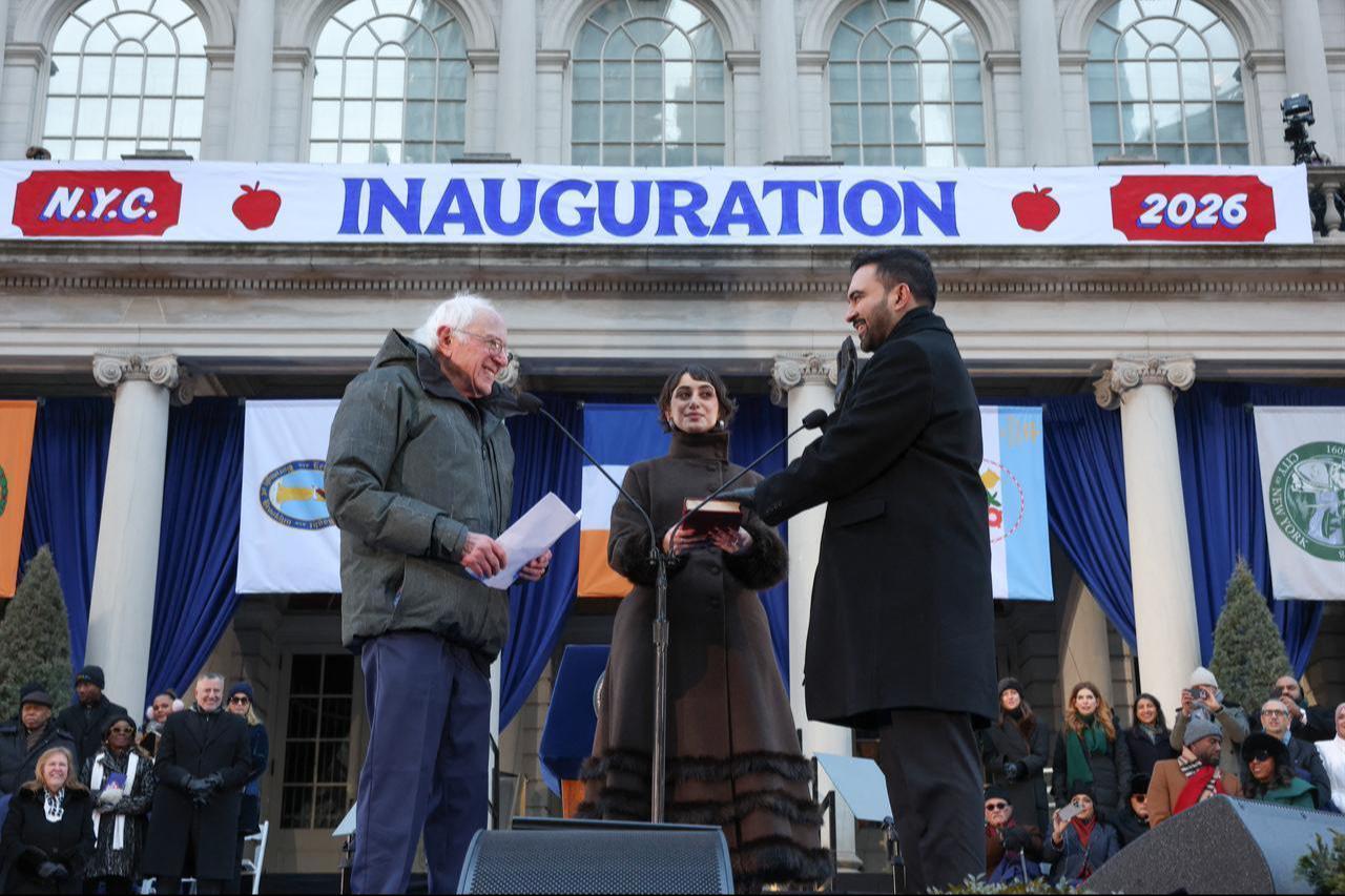 US Senator Bernie Sanders swears in New York mayor Zohran Mamdani as his wife Rama Duwaji holds the Koran during his public inauguration ceremony followed by a block party at City Hall in New York on January 1, 2026.  (AFP Photo)