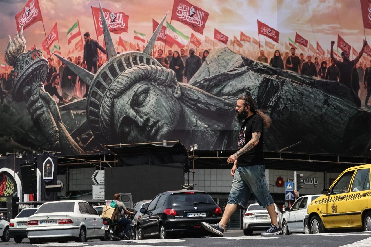 An Iranian man walks past an anti-US billboard at Enghelab Square in central Tehran, August 3, 2026. (AFP Photo)