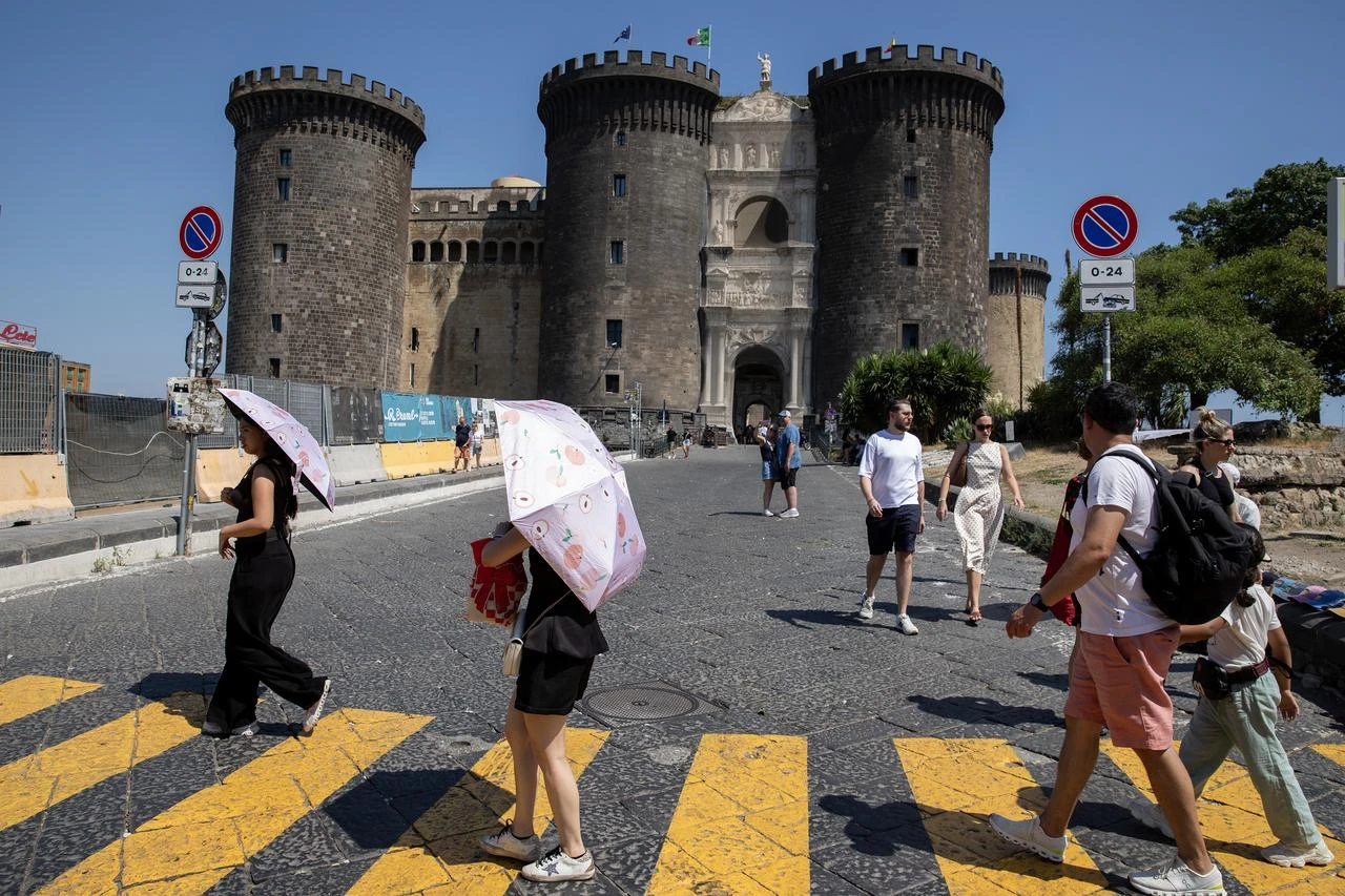 People use umbrellas to protect themselves from the sun on a warm afternoon in Naples, Italy, Aug. 01, 2026. (AA Photo)