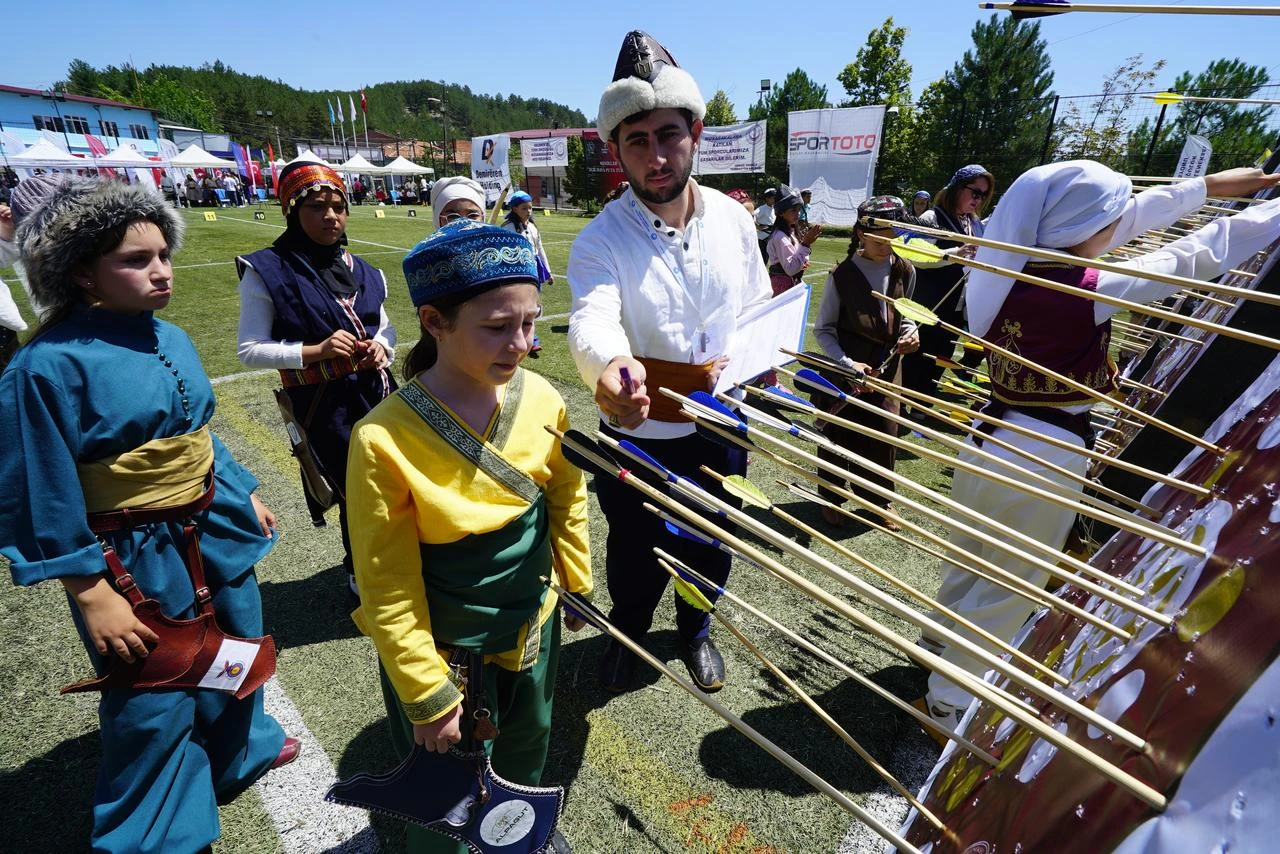 Young archers in traditional attire compete and inspect their targets during the Turkish Traditional Archery Minors and Cadets Championship in Kütahya, Türkiye, Aug. 2, 2026. (AA Photo)