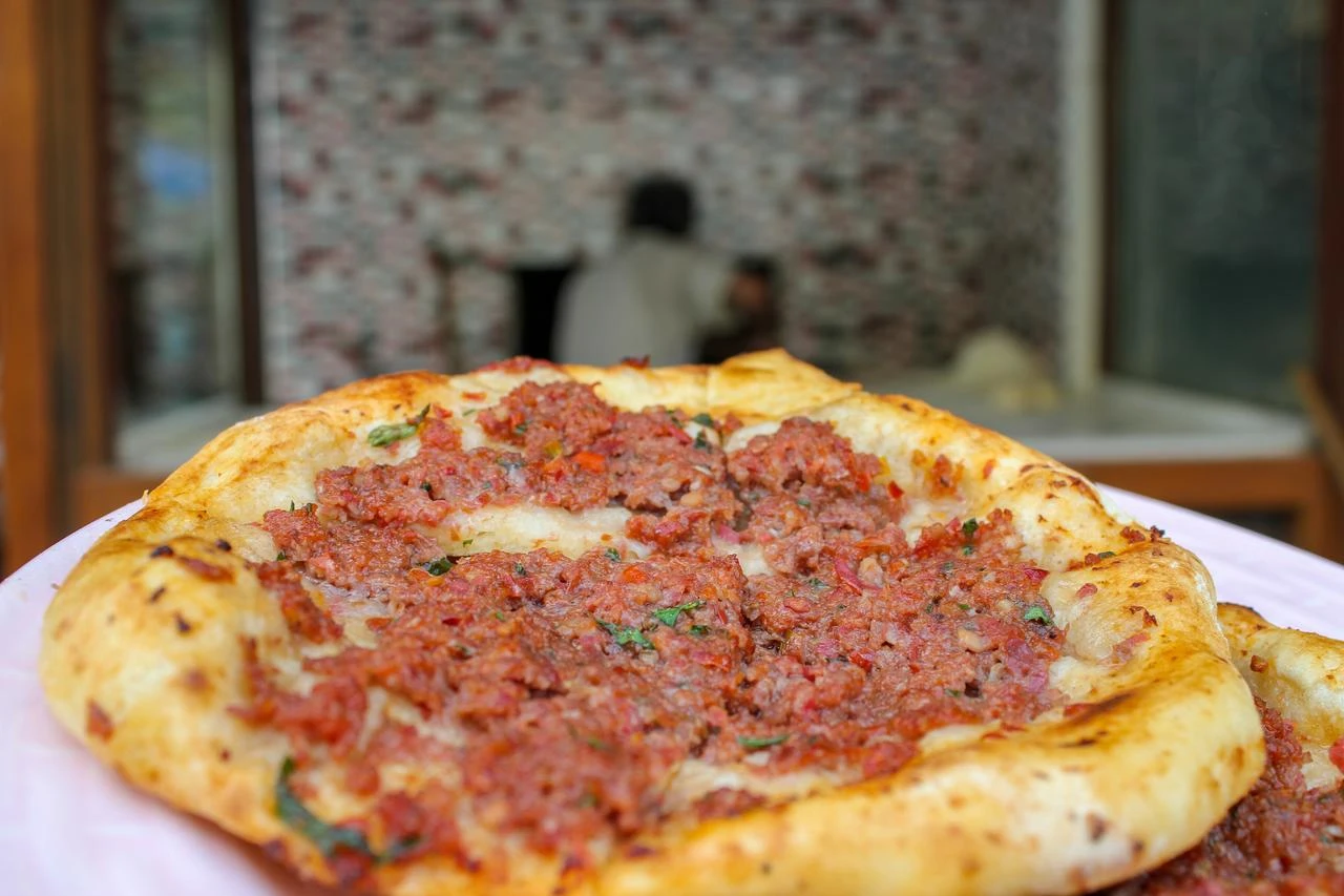 A freshly baked round cantik pide topped with seasoned minced meat is served at a traditional bakery. (Adobe Stock Photo)