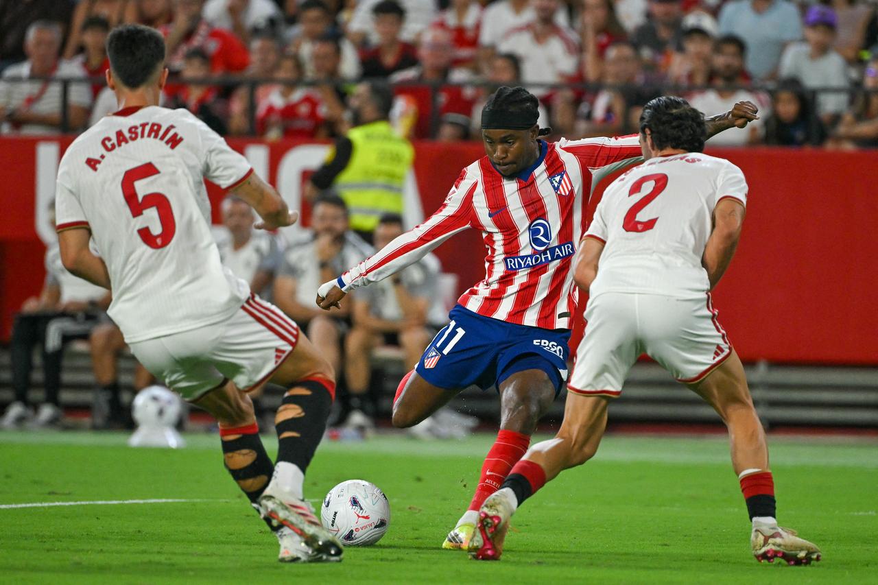 Atletico Madrid’s Ademola Lookman shoots between Sevilla defenders during their La Liga match at Ramon Sanchez-Pizjuan Stadium in Seville, Spain, Aug. 29, 2026. (AFP Photo)