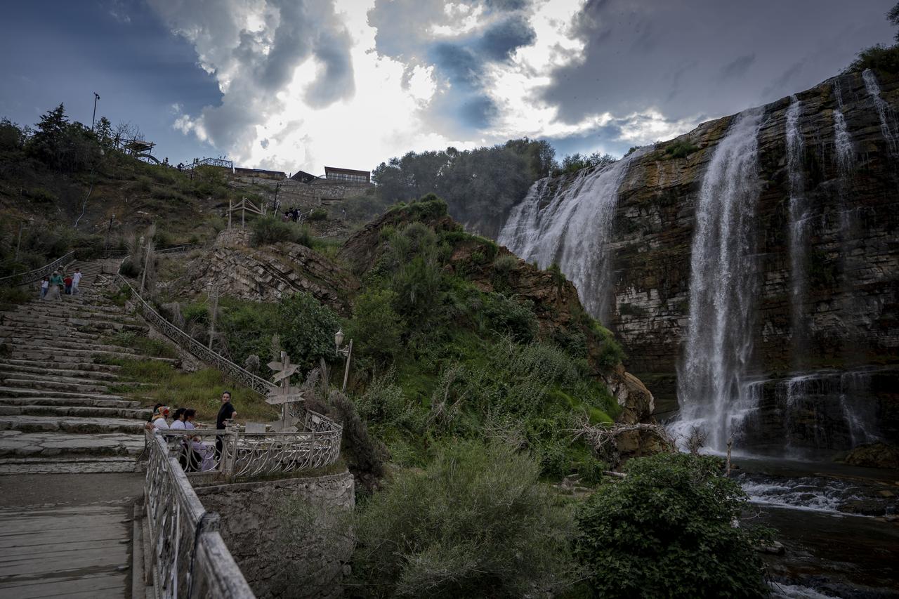 Visitors walk along viewing terraces beside Tortum Waterfall in Erzurum, Türkiye, Aug. 29, 2026. (AA Photo)