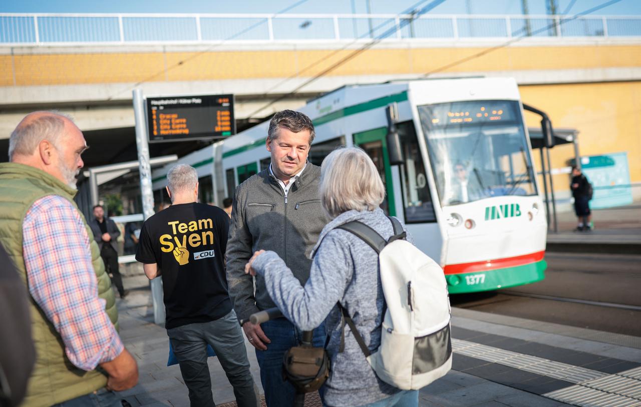 Sven Schulze (2nd R), Saxony-Anhalt's State Premier and the Christian Democratic Union (CDU) party's top candidate in the Saxony-Anhalt state election, speaks with a passerby during a campaign event held at a tram stop near the main train station on August 27, 2026 in Magdeburg, eastern Germany. (AFP Photo)