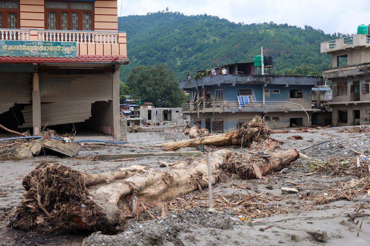 Flood debris, uprooted trees and damaged buildings are seen in an affected area of Nepal following deadly flash floods, Aug. 29, 2026. (AA Photo)