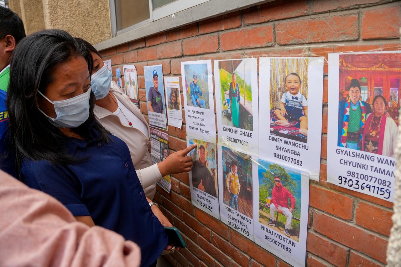 Relatives look at photographs of people reported missing after devastating flash floods, outside Tribhuvan University Teaching Hospital in Kathmandu, Nepal, Aug. 28, 2026. (AA Photo)
