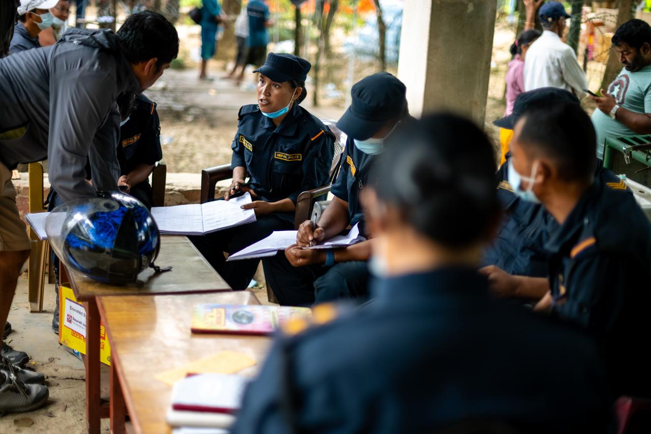 Nepal Police officers speak with residents at a military camp as flood survivors await evacuation and information about missing relatives in Bidur, Nuwakot district, Nepal, Aug. 29, 2026. (AA Photo)