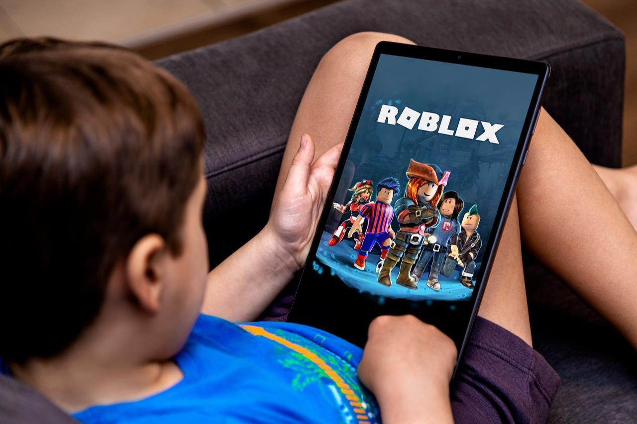 Little boy playing a Roblox game on a tablet. (Photo via Adobe Stock)