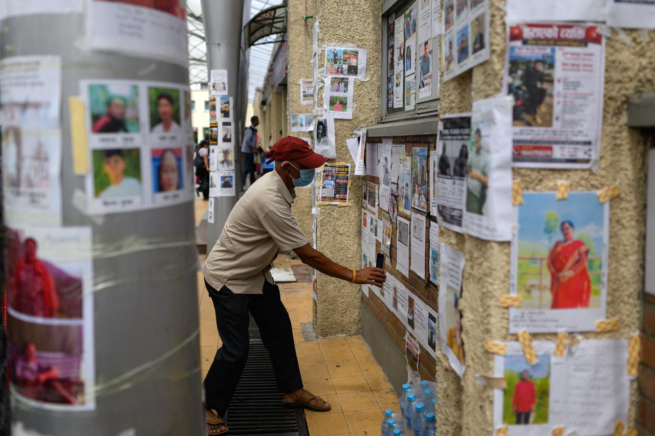 A man looks at photographs of missing persons in the aftermath of flash floods at the Tribhuvan University Teaching Hospital in Kathmandu on August 31, 2026. (AFP Photo)