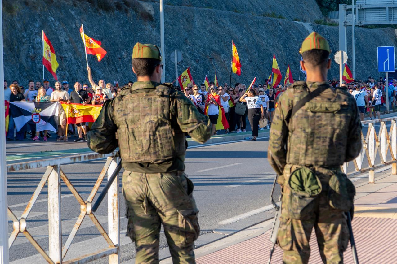 Spanish soliders look on as demonstrators carry Spanish flags during a protest against the presence of migrants and the situation after the arrival of tens of thousands of migrants last month in Ceuta, Spain, on August 29, 2026. (AFP Photo)