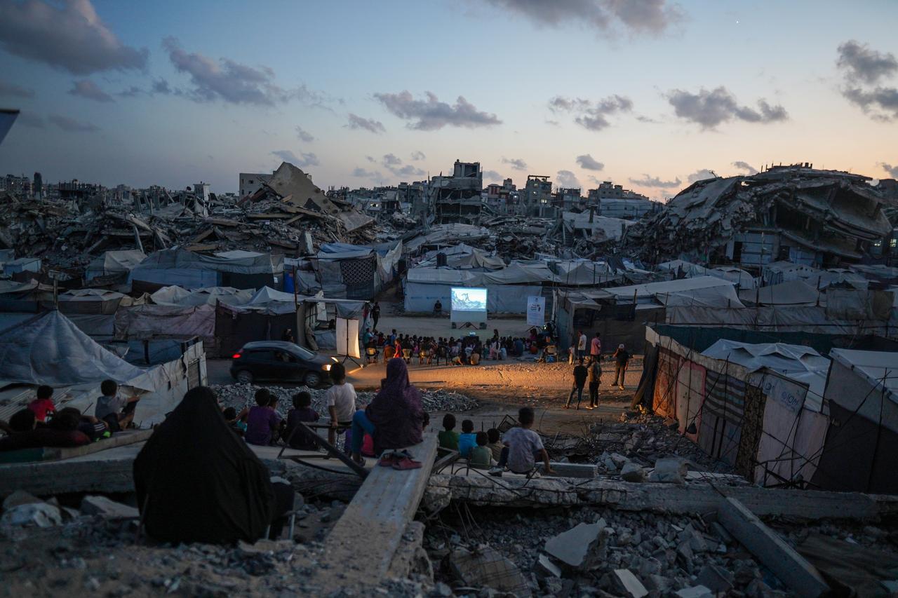 Palestinian children gather amid the rubbles for an outdoor cartoon screening that is organized with the support of a charitable foundation for children among damaged buildings in the Sheikh Radwan neighborhood of Gaza City, Palestine on August 30, 2026.  (AA Photo)